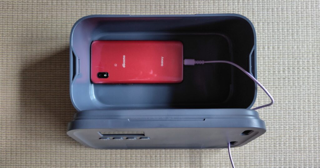 タイムロッキングコンテナにスマホを入れて充電している様子